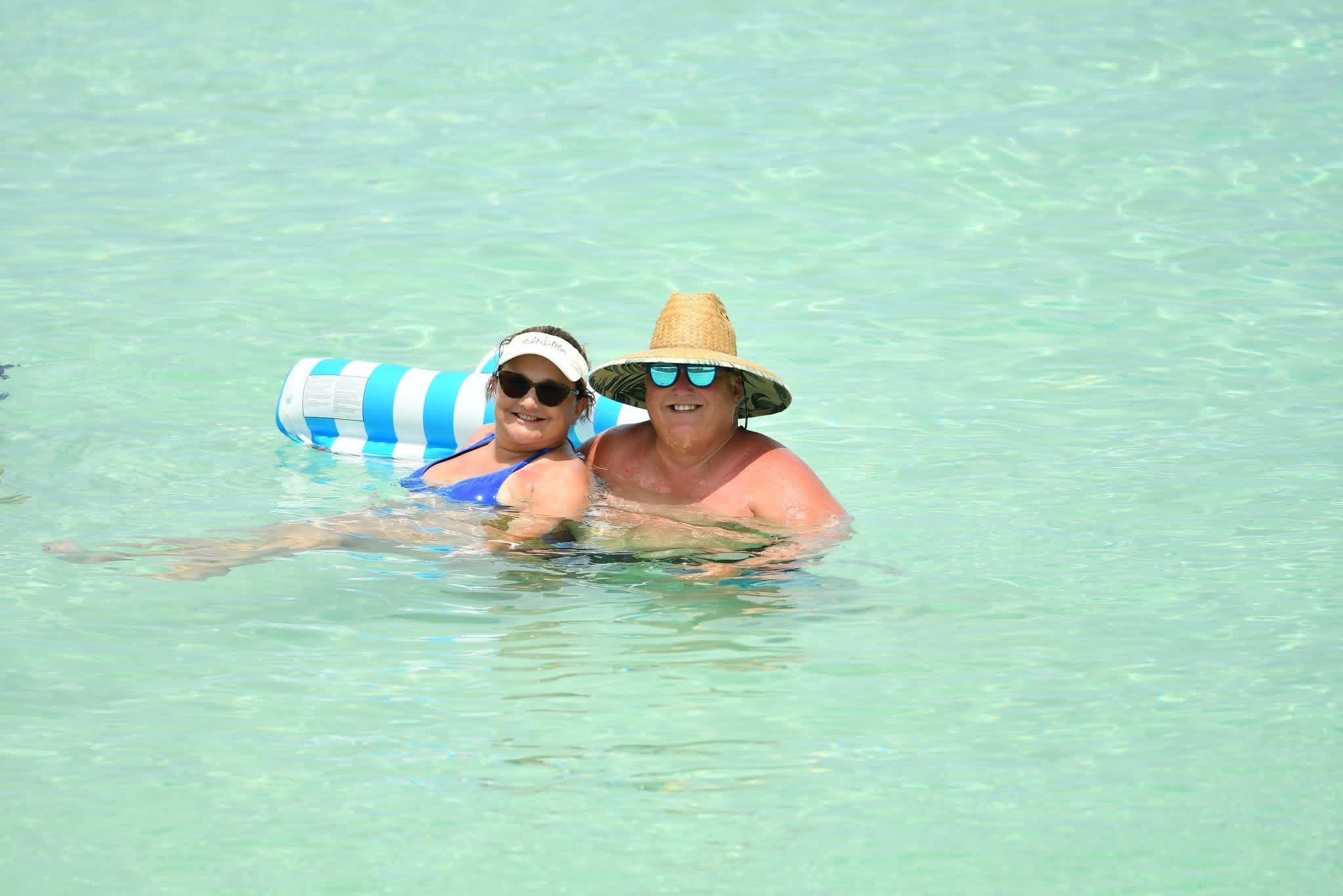 Sandy & Craig Holton floating in clear turquoise water at Sandals Royal Bahamian