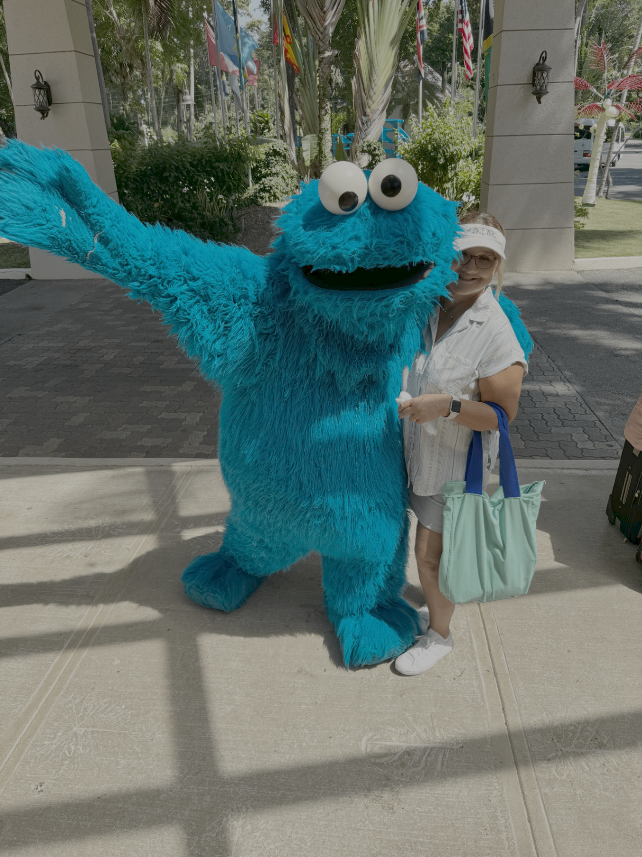 Sandy Holton hugging Cookie Monster at the entrance to Beaches Negril, Jamaica, in 2022
